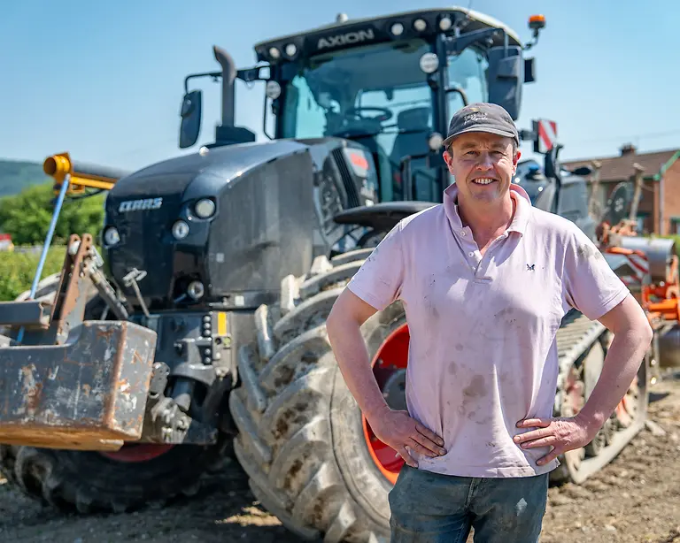 Exploitant agricole devant un tracteur professionnel